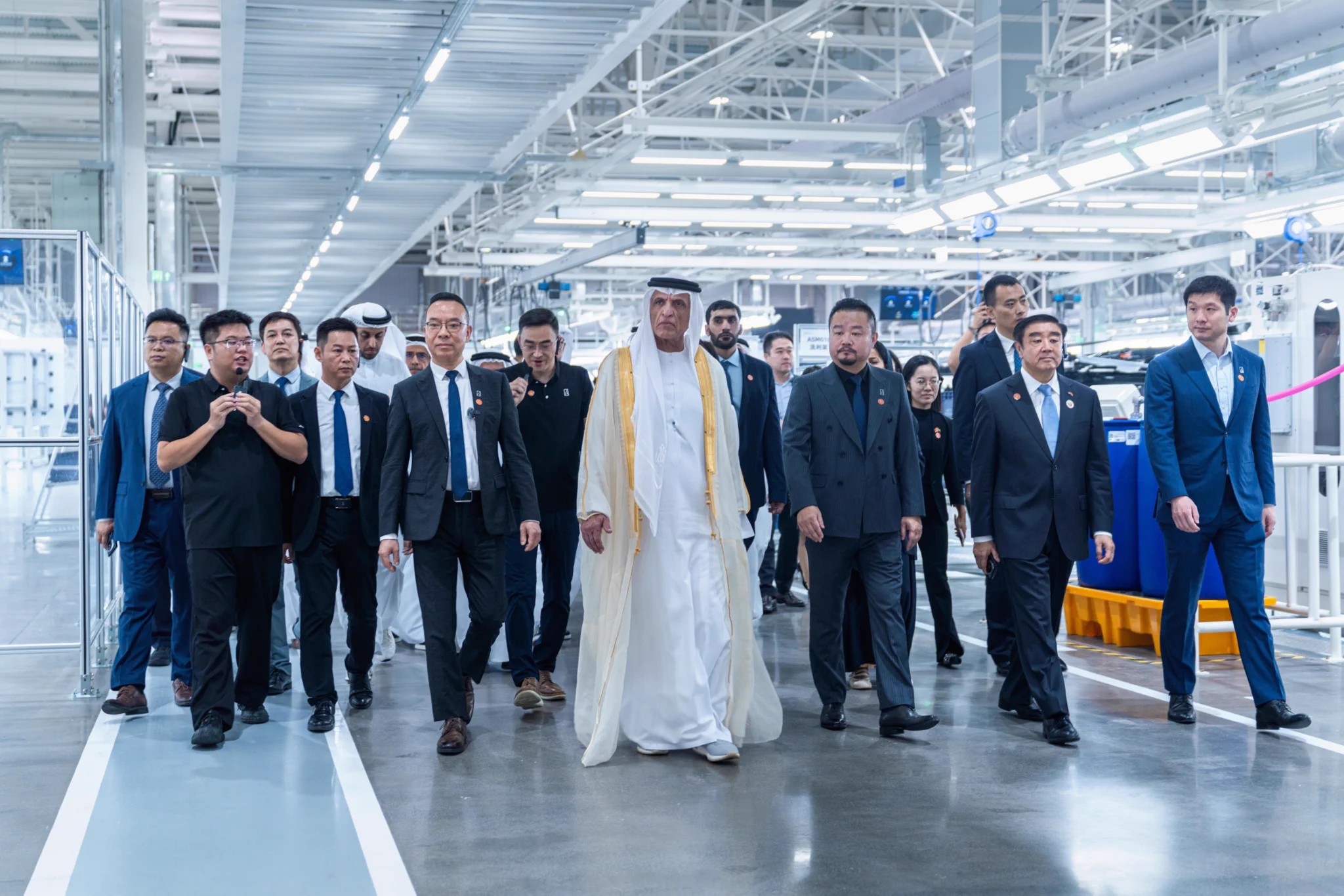 Sheikh Saud bin Saqr Al Qasimi walking through the factory hall in Guangzhou with a group of guests and hosts