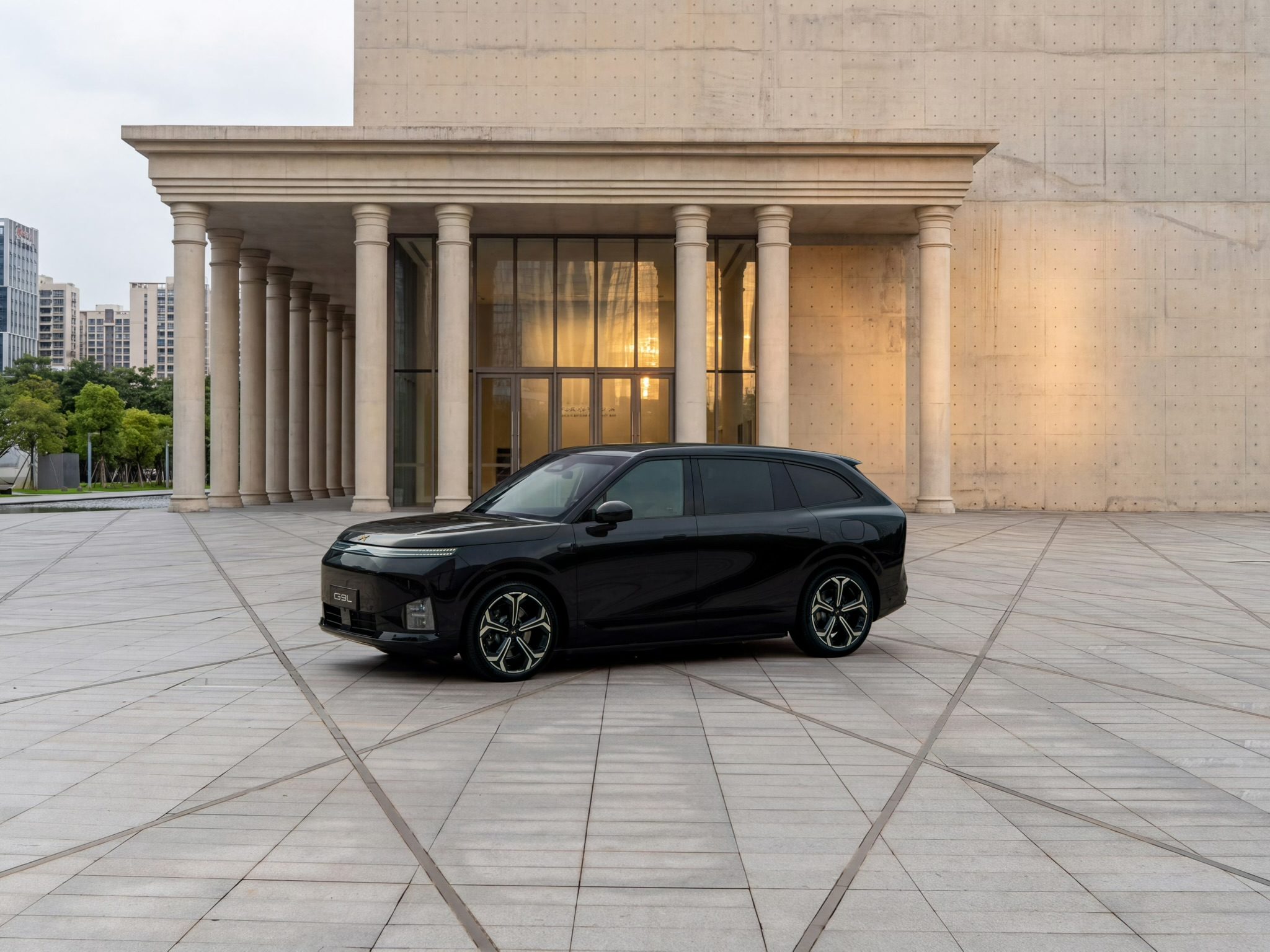 XPENG G9L Black Gold Edition on a paved plaza in front of a colonnade