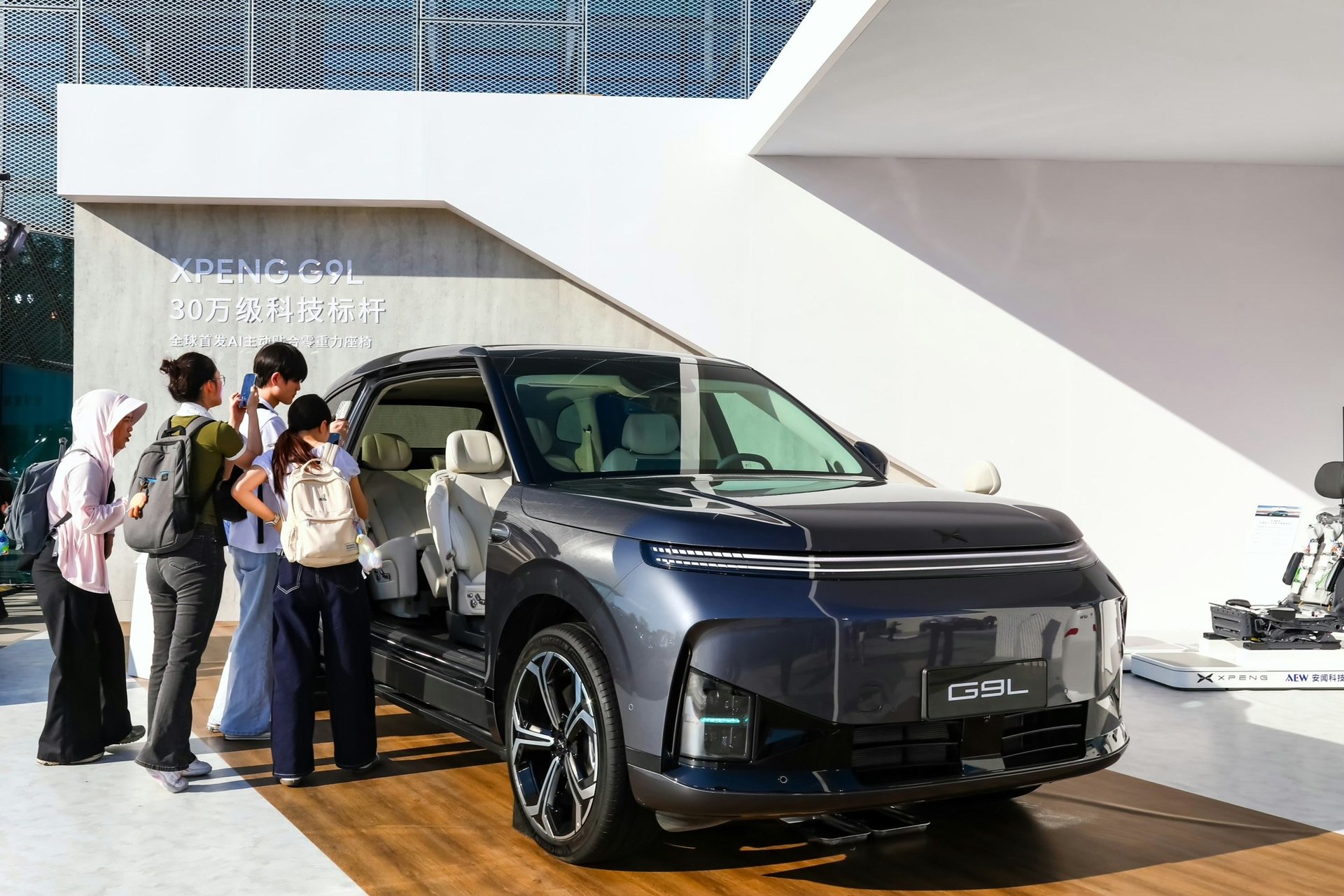 XPENG G9L display with open door and AI Active Fit seat messaging