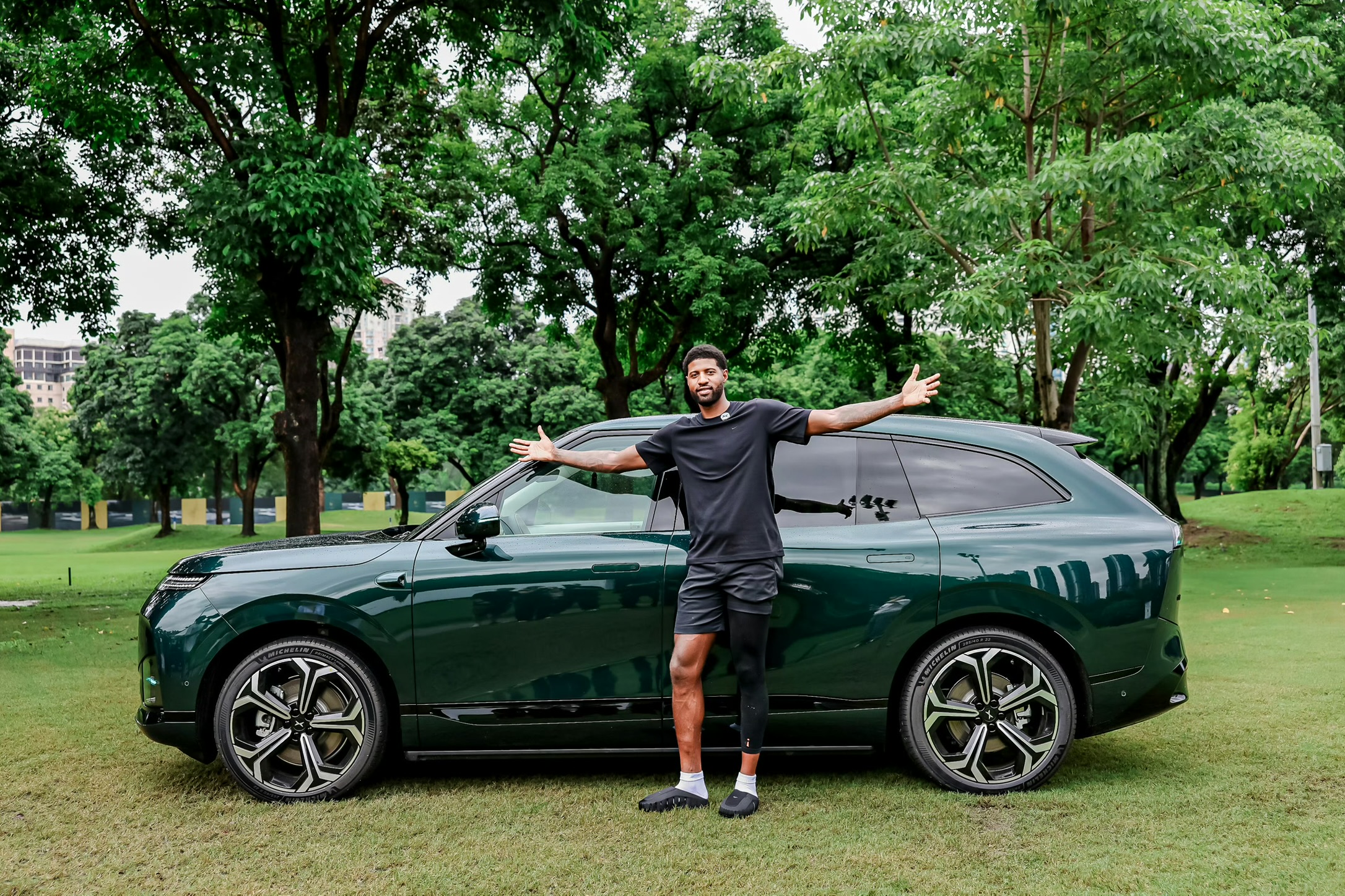 XPENG G9L i Toscana Green med Paul George stående ved sideprofilen udendørs