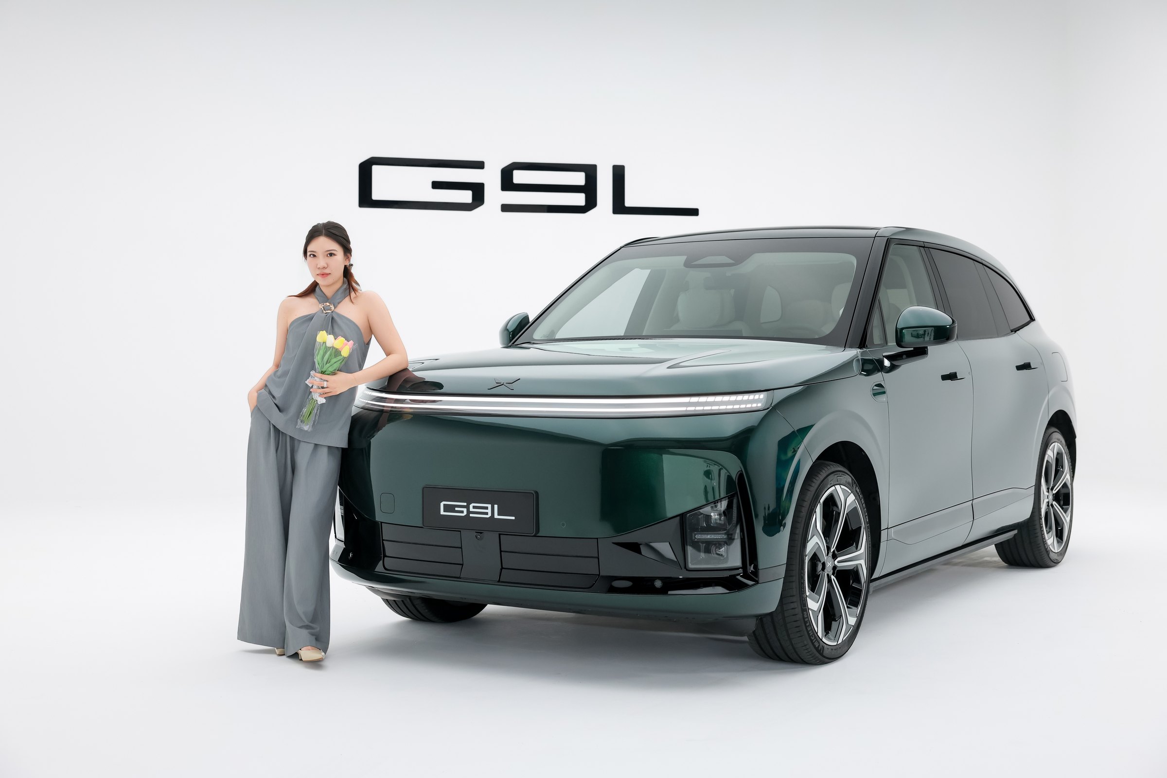 XPENG G9L i Toscana Green forfra/trekvart i et hvidt studie med model
