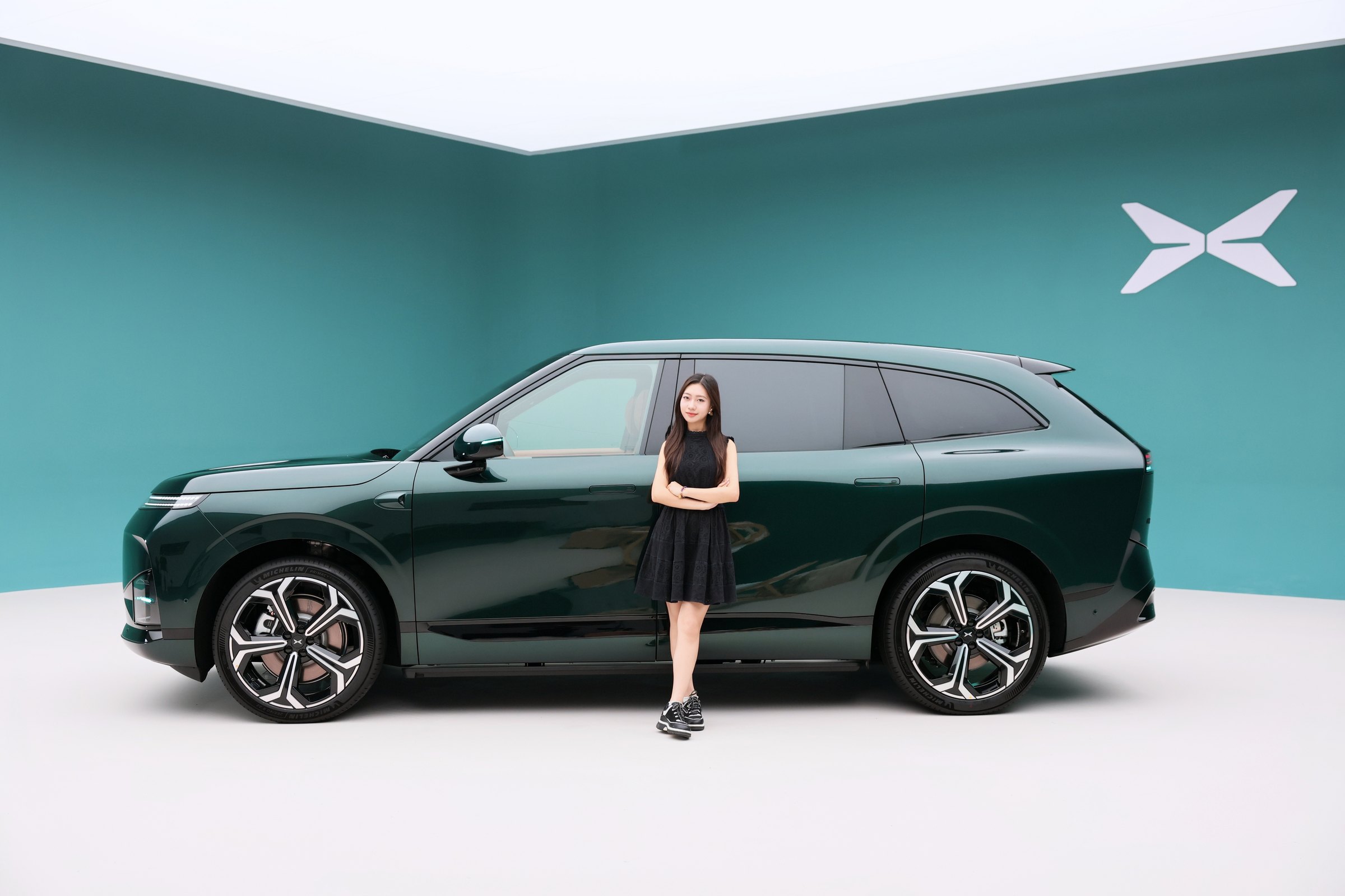 XPENG G9L i Toscana Green sideprofil i et teal-studie med model