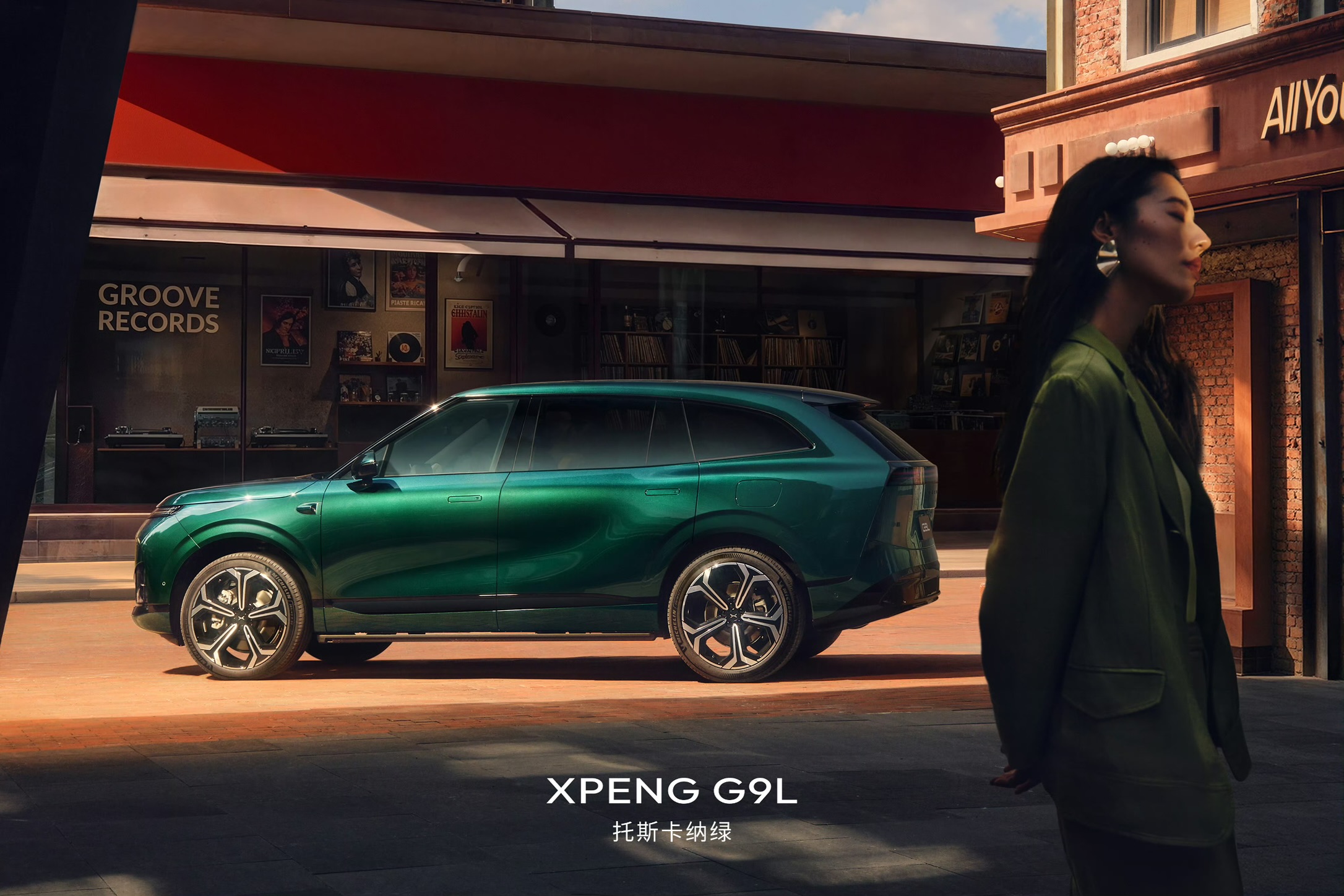 XPENG G9L sideprofil i Toscana-grøn foran en pladeforretning