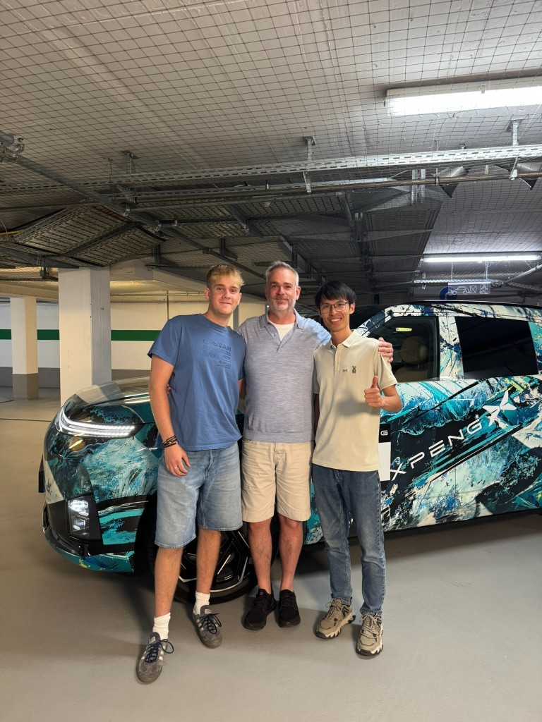 Me (centre) with son (left) and Ye Zhiming, G9L Overseas Product Expert (right), beside a camouflaged G9L in Munich