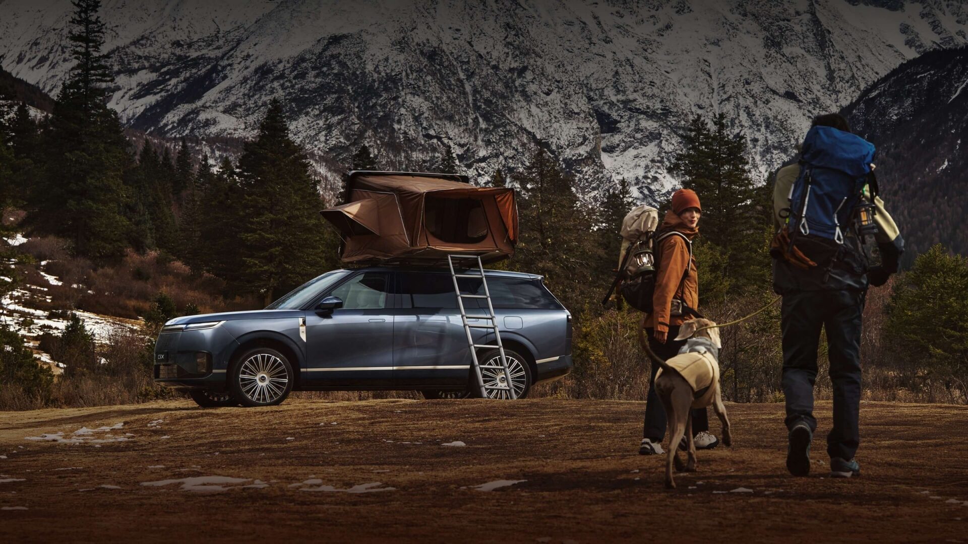 XPENG GX with rooftop tent and hikers in snowy mountains