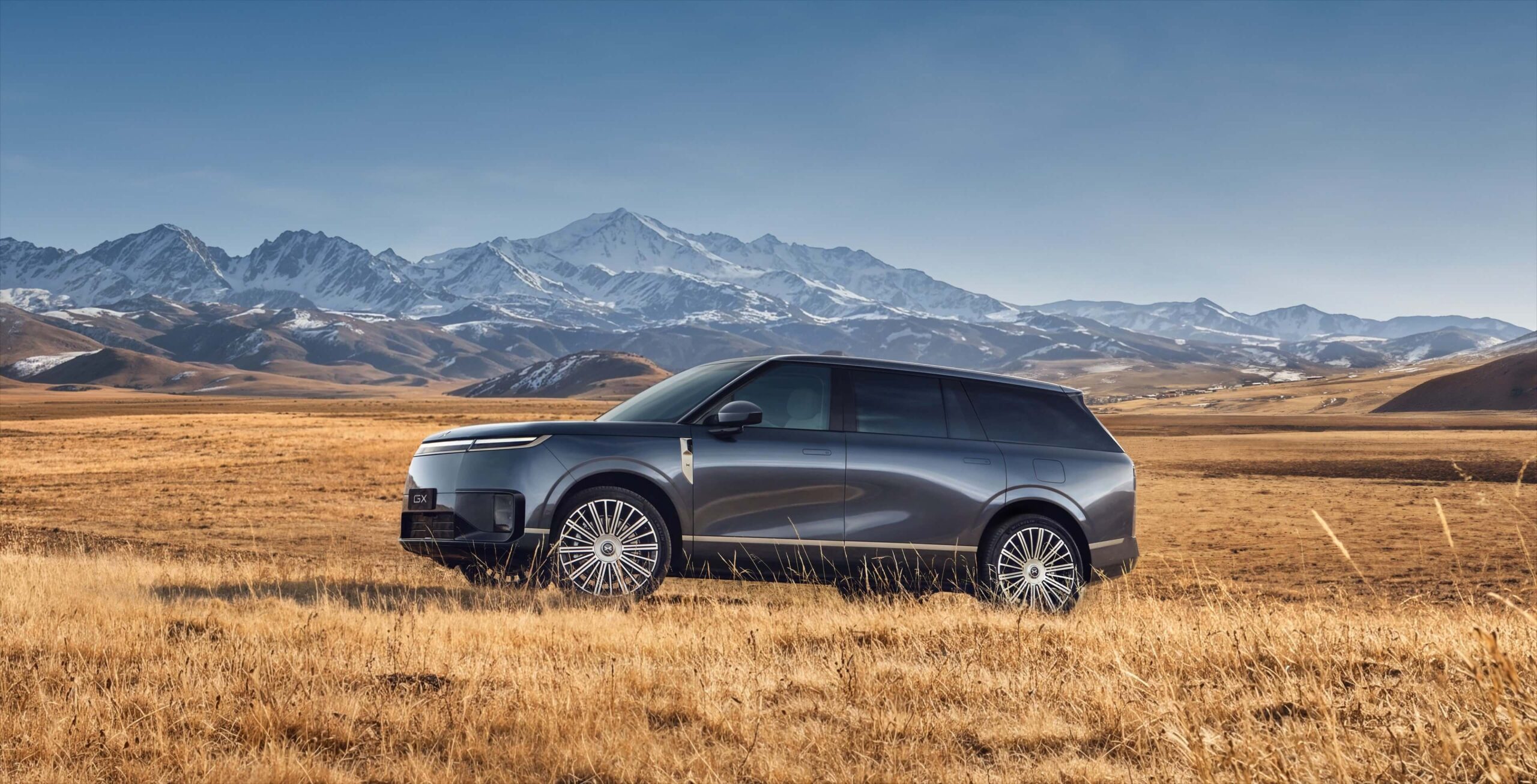XPENG GX front three-quarter view in a mountain grassland