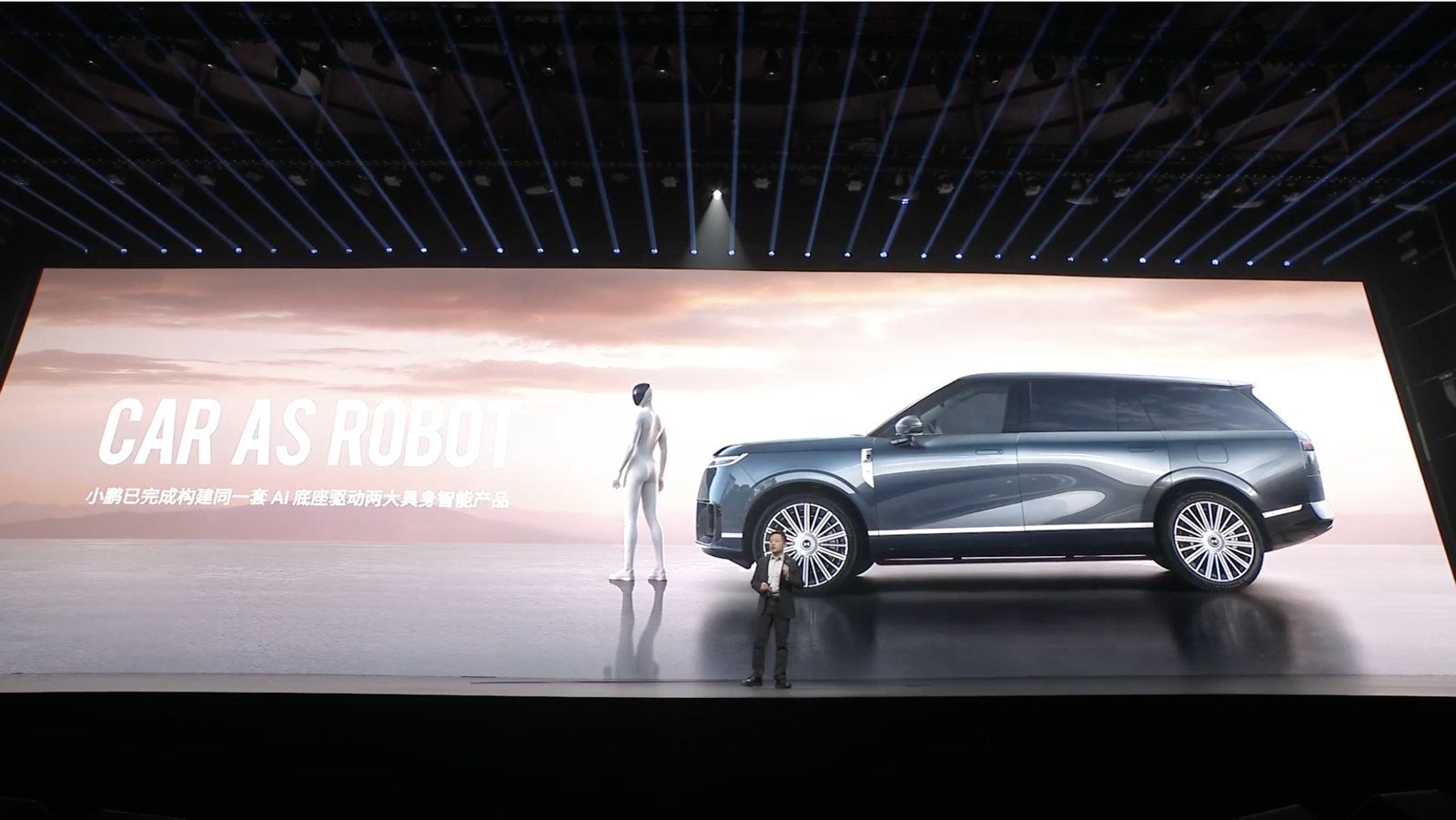 He Xiaopeng in front of a screen showing IRON and an XPENG GX under the heading Car as Robot
