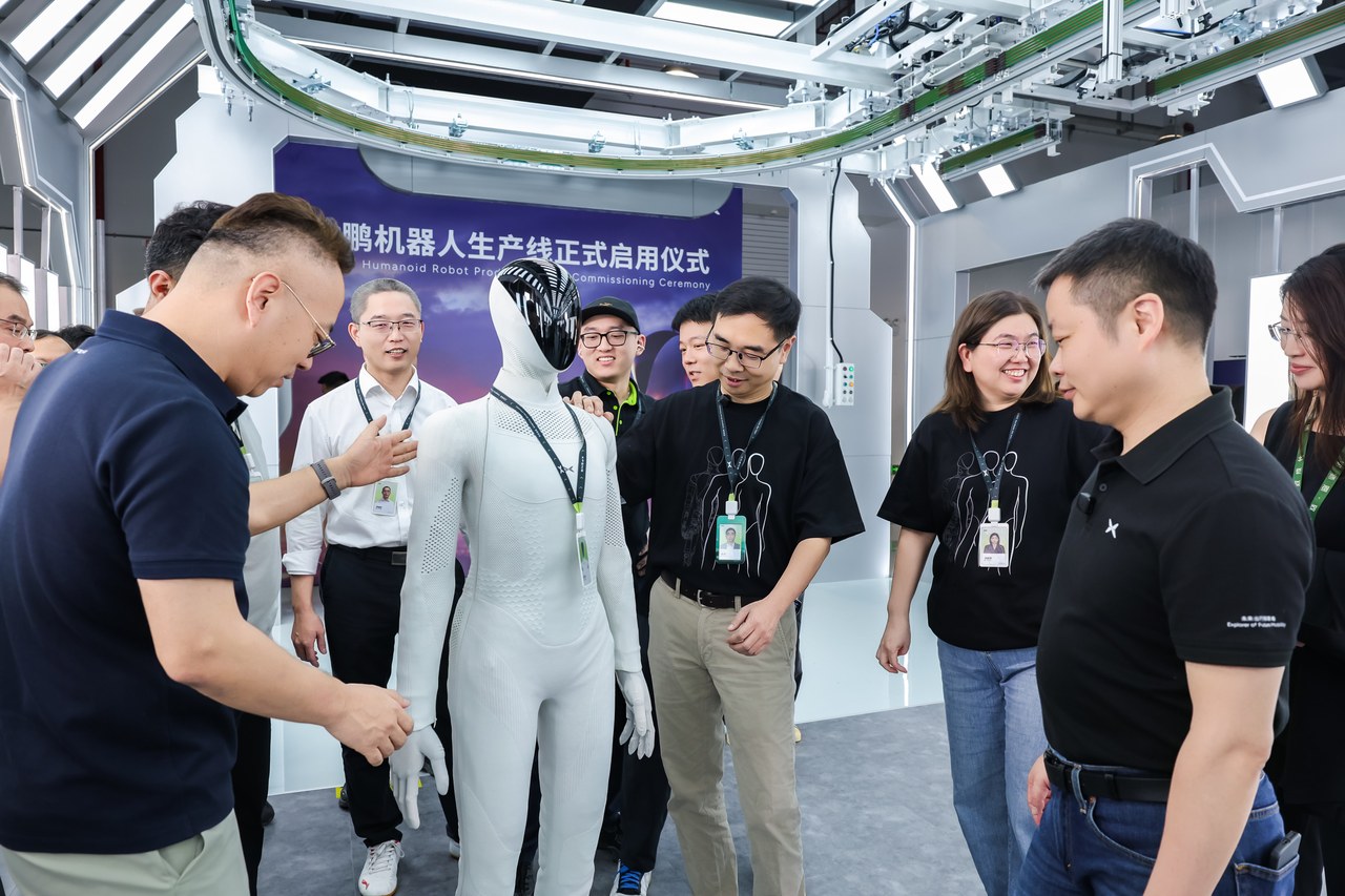 XPENG staff gathered around a white IRON at the commissioning of the production line