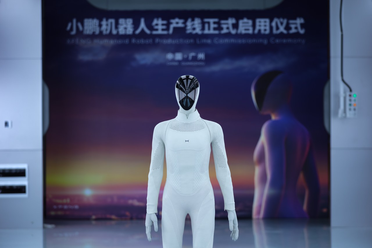 IRON standing on stage in front of the banner for the production line commissioning ceremony in Guangzhou