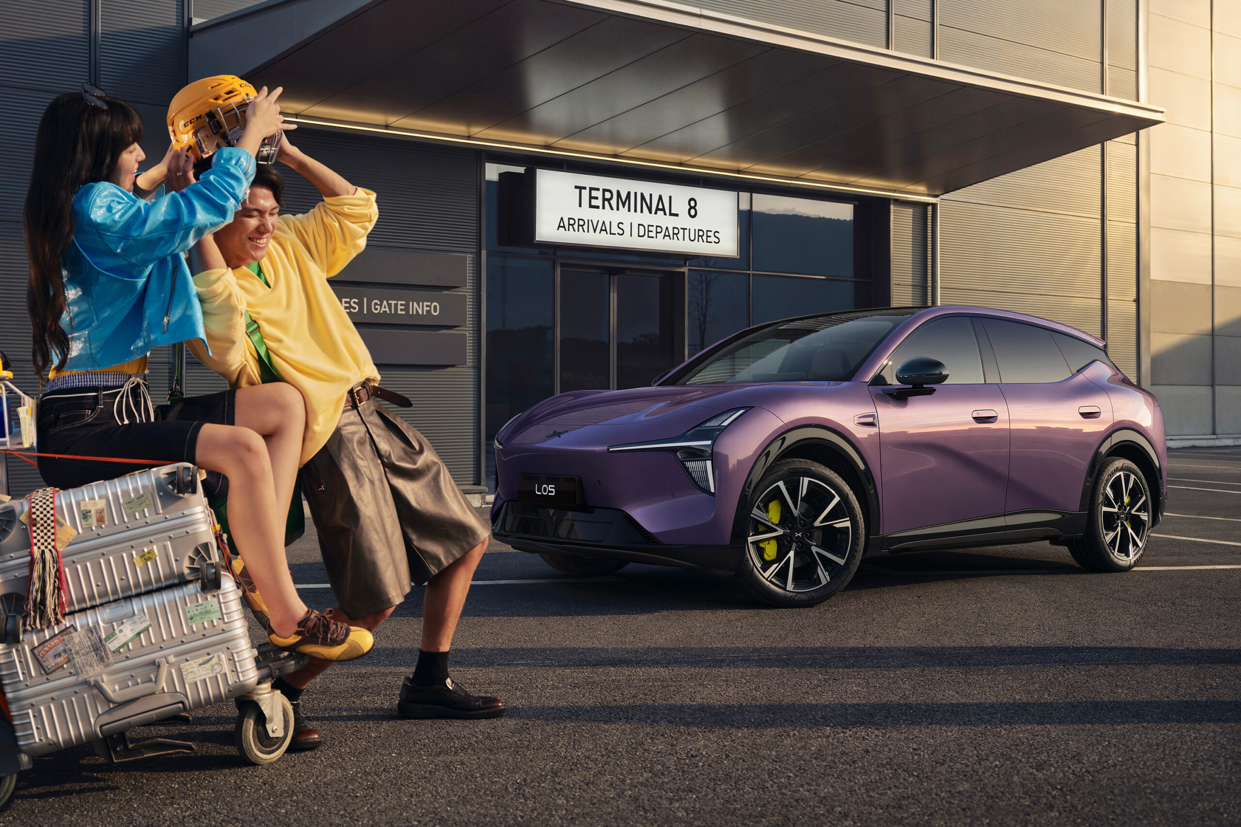 Purple L05 outside a terminal with passengers and luggage