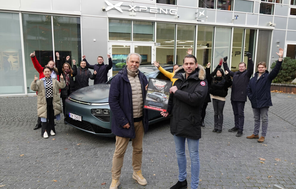 XPENG G9 på norske plader foran en norsk XPENG-butik, med medarbejdere der fejrer