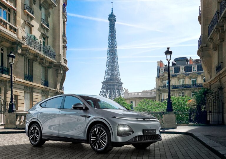 Silver XPENG G6 on a cobbled Paris street with the Eiffel Tower behind