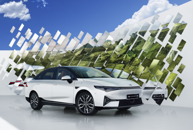 White XPENG P5 front three-quarter in a studio against a mirrored valley backdrop