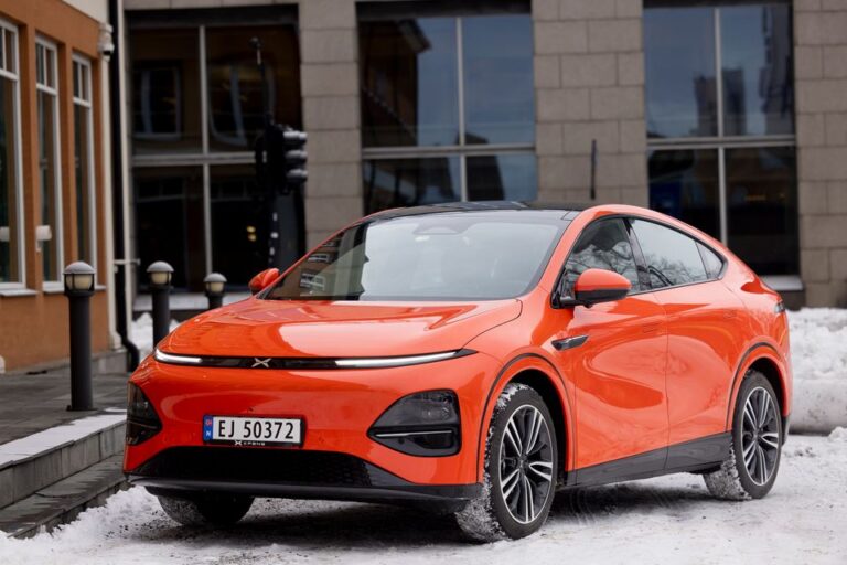 Orange XPENG G6 on Norwegian plates on a snow-lined street with winter tyres