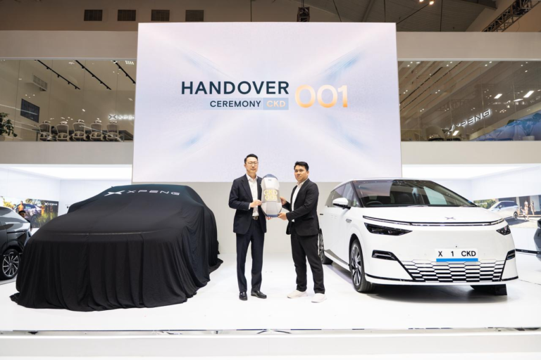 Handover of the first locally built XPENG X9 on a show stand under a screen reading Handover Ceremony CKD 001