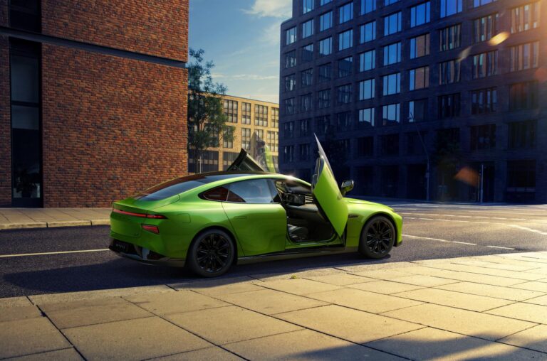 Bright green XPENG P7 Wing on a city street at low sun with one scissor door raised