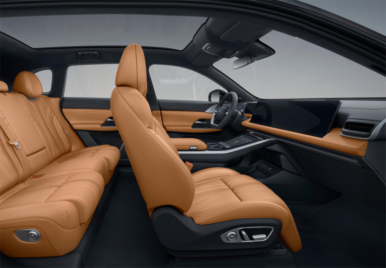 XPENG cabin in tan leather seen from the side, with the wide dashboard display running across the front