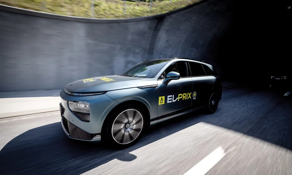 Mørkegrå XPENG G9 på vej ind i en tunnelmunding på en norsk vej med EL-PRIX-mærkater på dør og motorhjelm