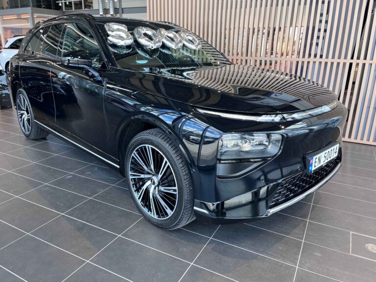 Black XPENG G9 in a Norwegian showroom with silver balloons spelling 5000 on the windscreen