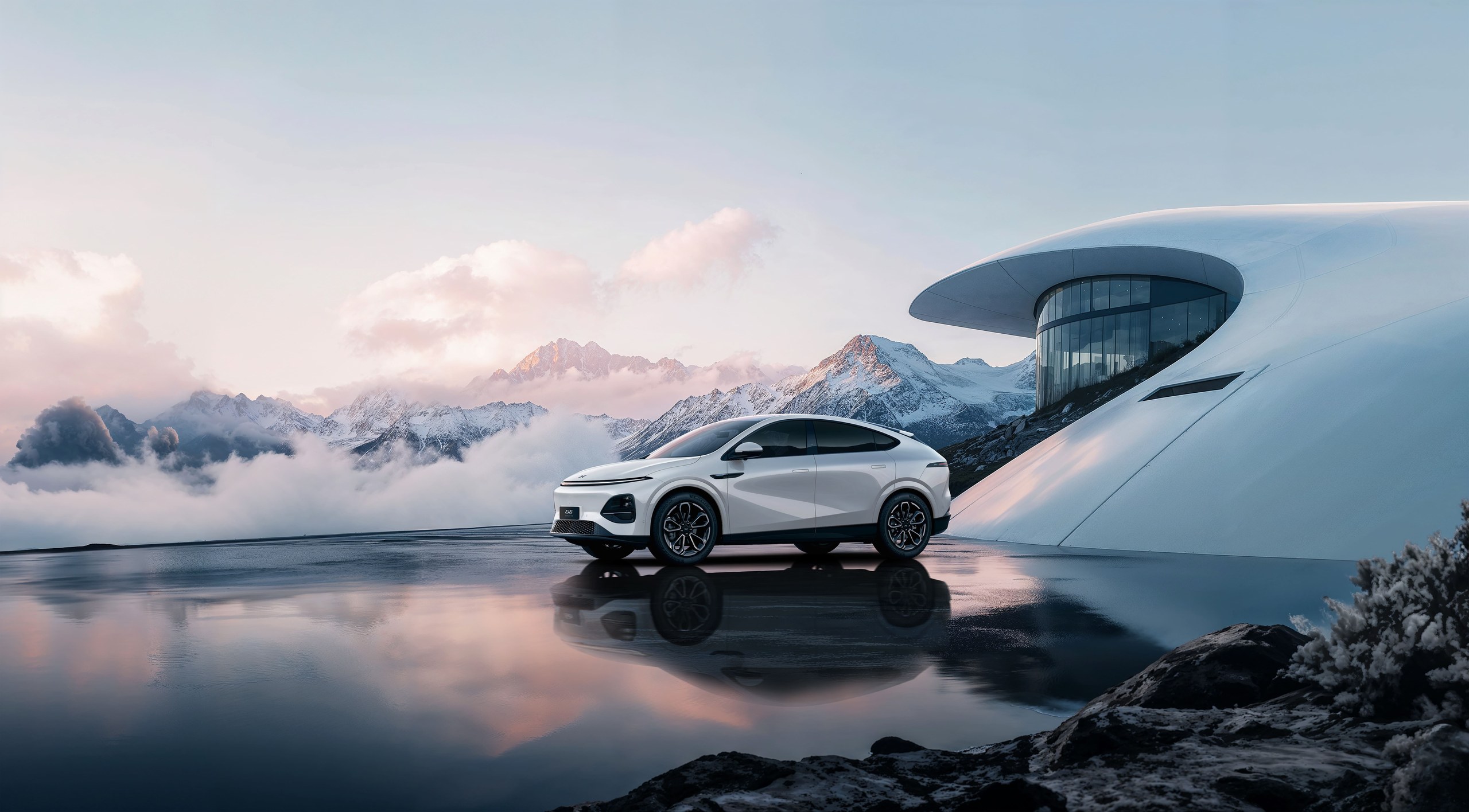 White New XPENG G6 in profile on a mirror-wet surface in front of a white curved building with snow peaks behind
