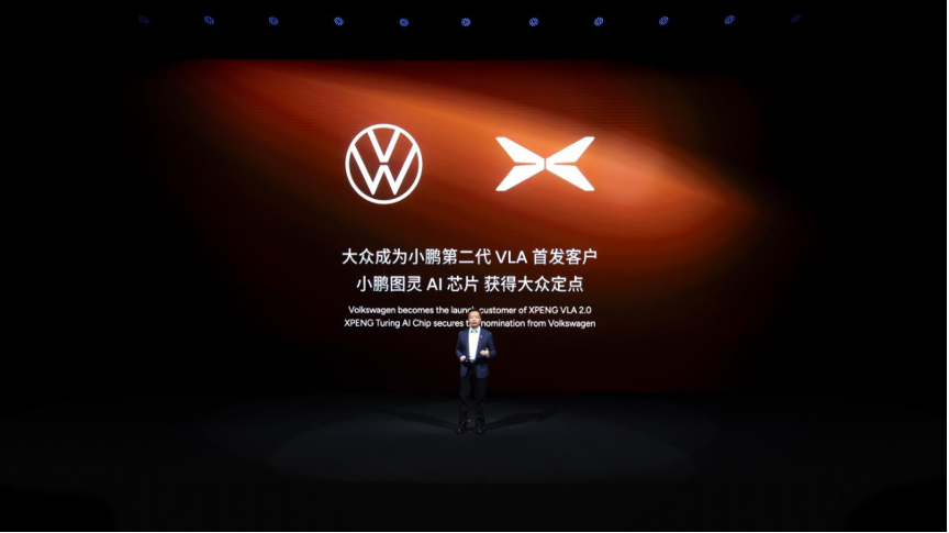 Volkswagen and XPENG logos side by side on a stage screen with a speaker standing below