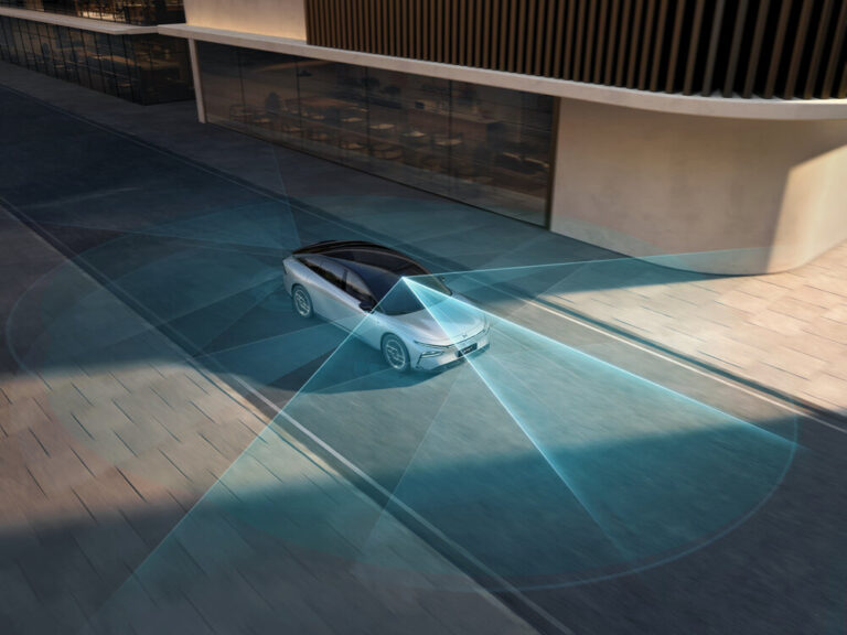 Computer graphic of a white XPENG sedan on a paved plaza with translucent blue sensor cones fanned out around it