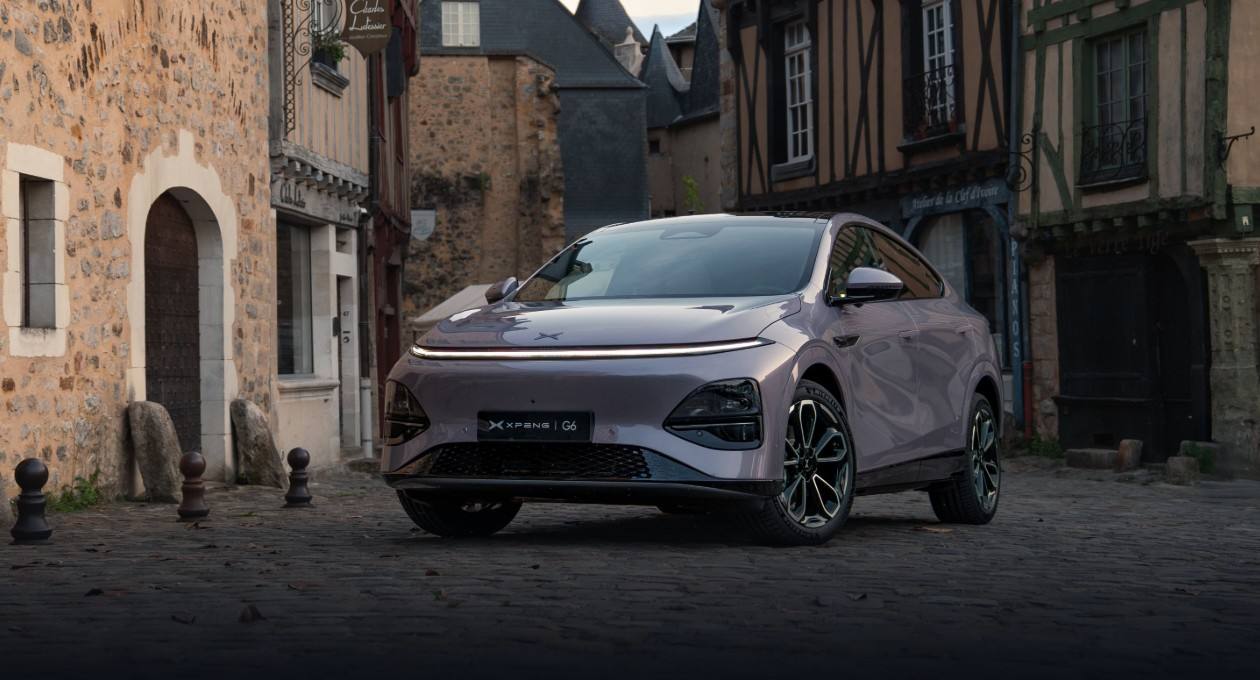 Stellar Purple XPENG G6 parked on cobbles in a narrow street of half-timbered and stone houses