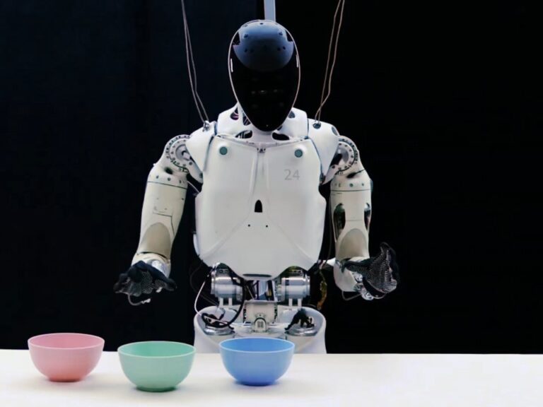 XPENG IRON humanoid robot i et teststativ foran tre skåle på et hvidt bord