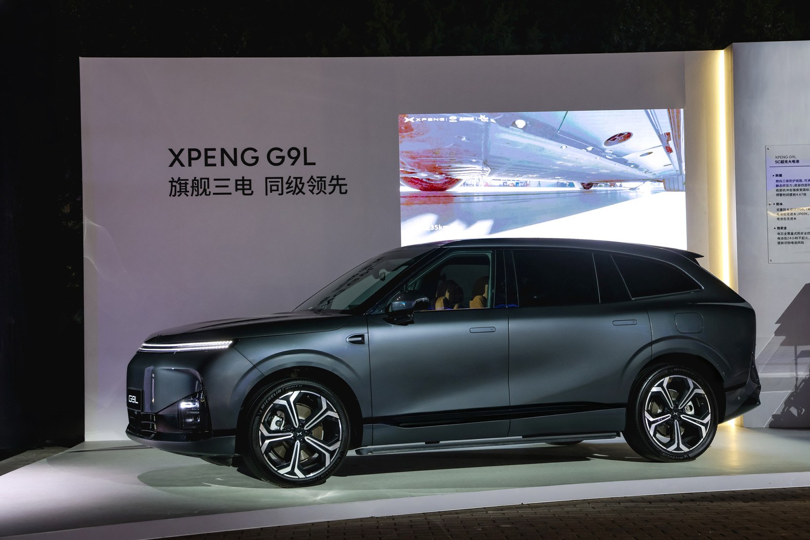 En mørkegrå XPENG G9L i sideprofil på lanceringsscenen i Beijing