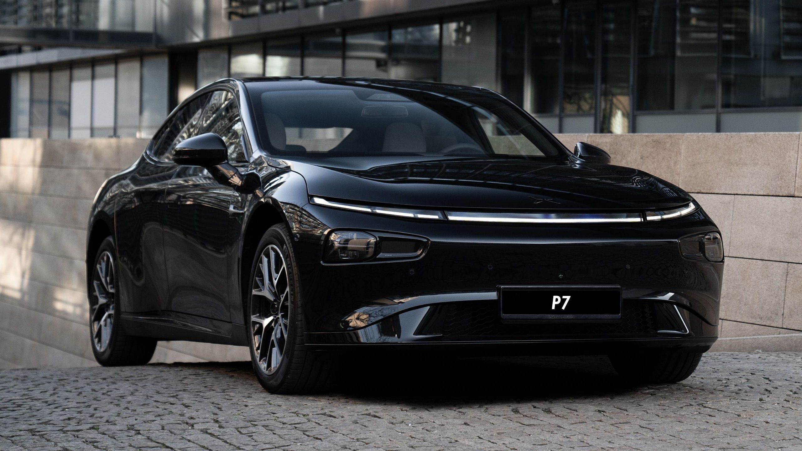 XPENG P7 i Jet Black, skråt forfra på brosten