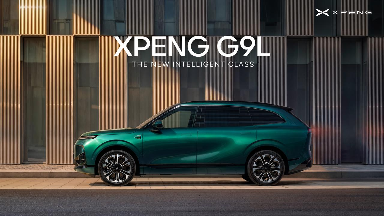 Green XPENG G9L in side profile outside a building