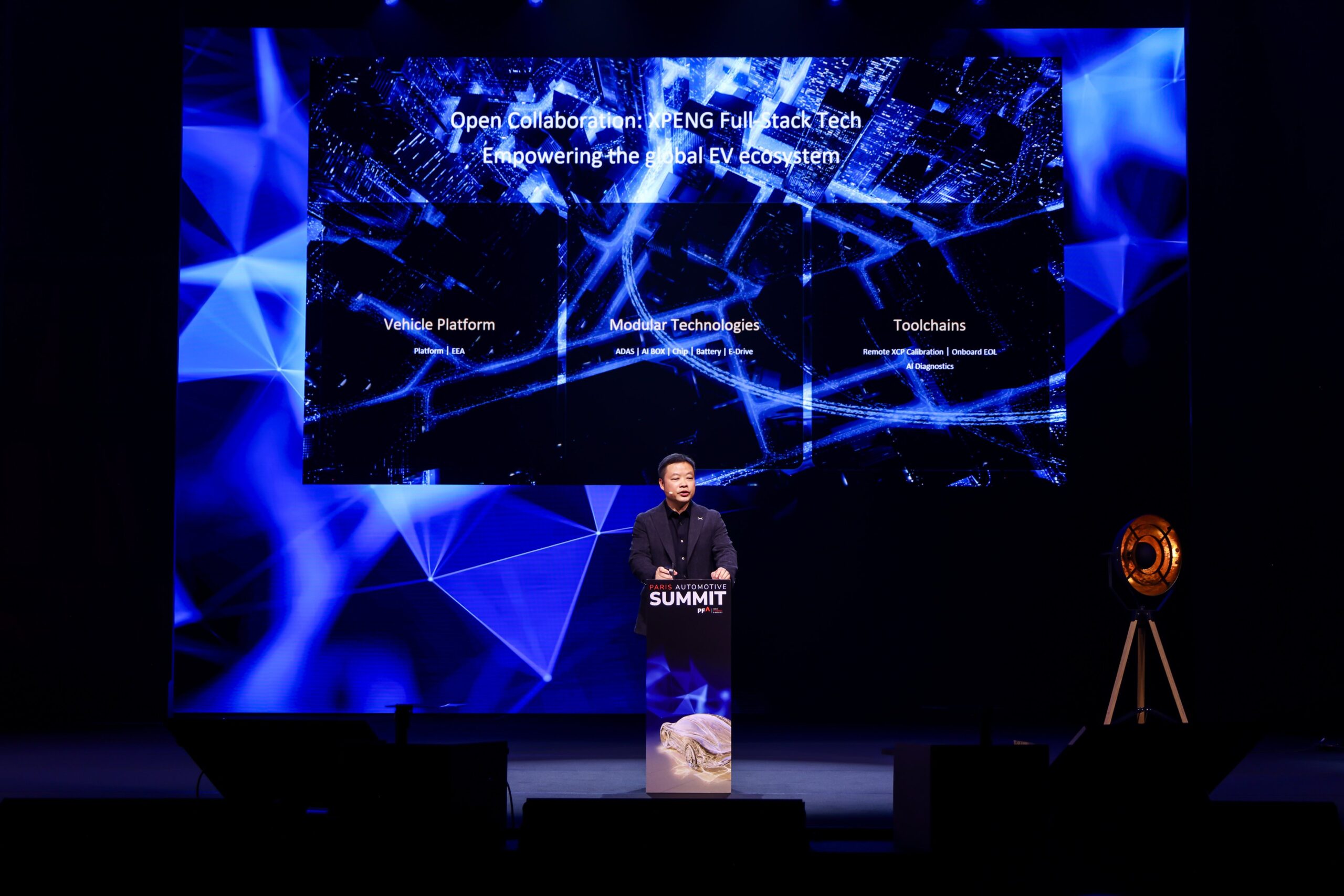 He Xiaopeng foran et slide med tre felter: Vehicle Platform (Platform, EEA), Modular Technologies (ADAS, AI BOX, Chip, Battery, E-Drive) og Toolchains (Remote XCP Calibration, Onboard EOL, AI Diagnostics)