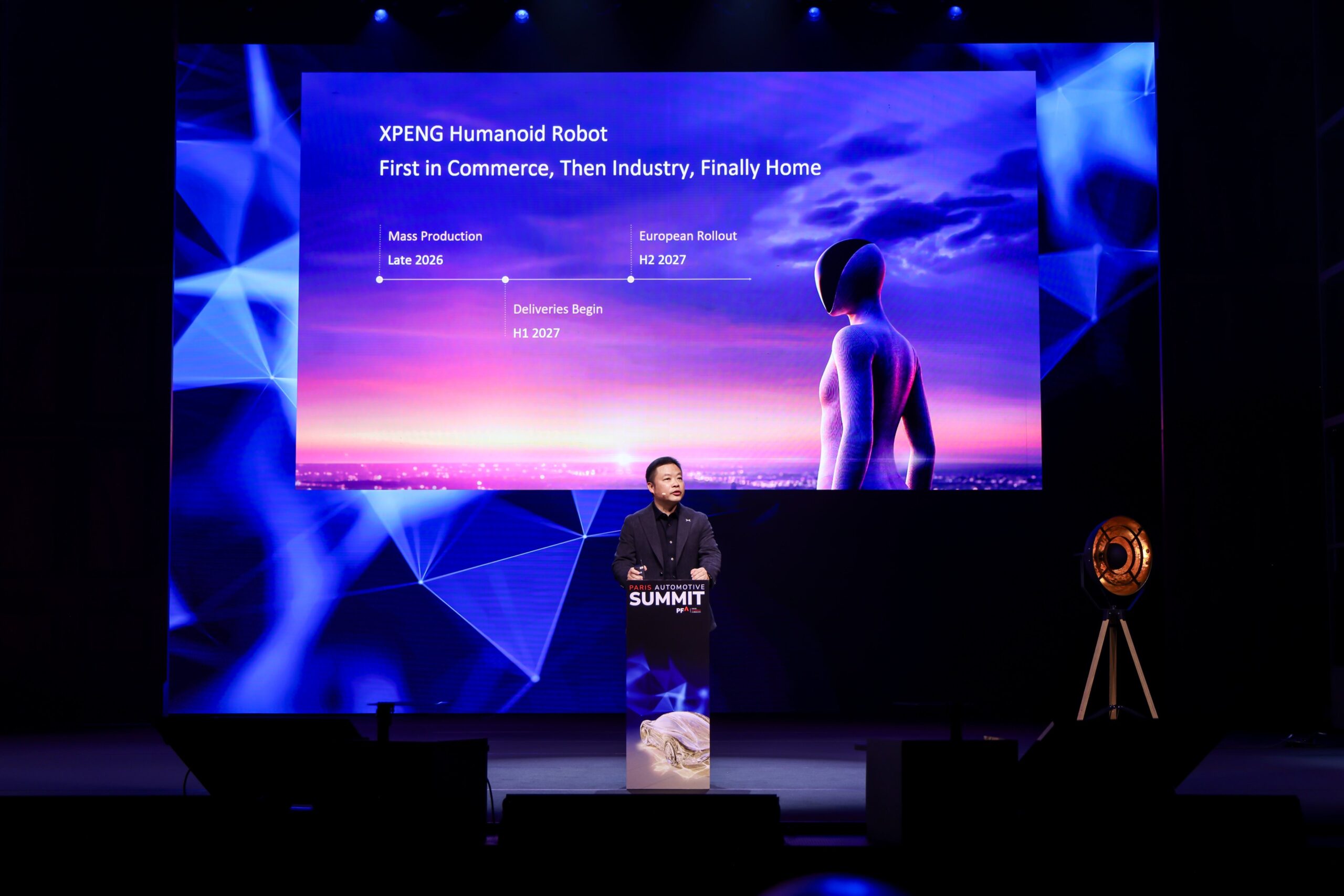 He Xiaopeng foran et slide med overskriften XPENG Humanoid Robot, First in Commerce, Then Industry, Finally Home, og en tidslinje: Mass Production Late 2026, Deliveries Begin H1 2027, European Rollout H2 2027