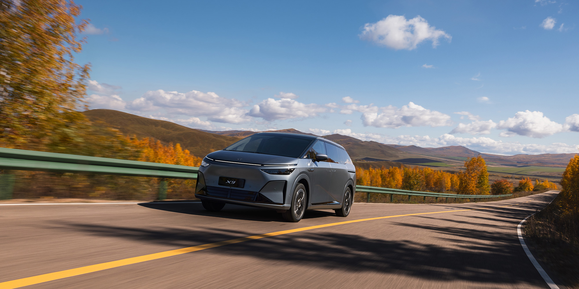 XPENG X9 on a winding autumn road through hills