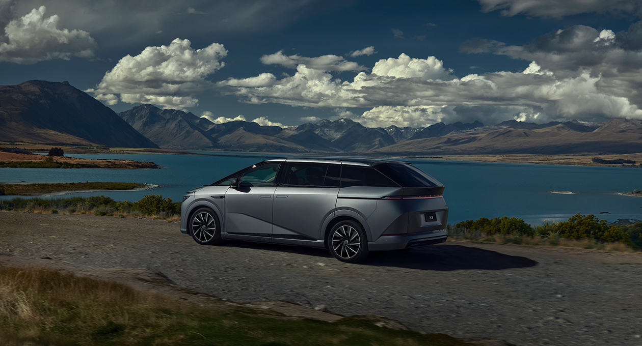 XPENG X9 rear three-quarter view at a mountain lake