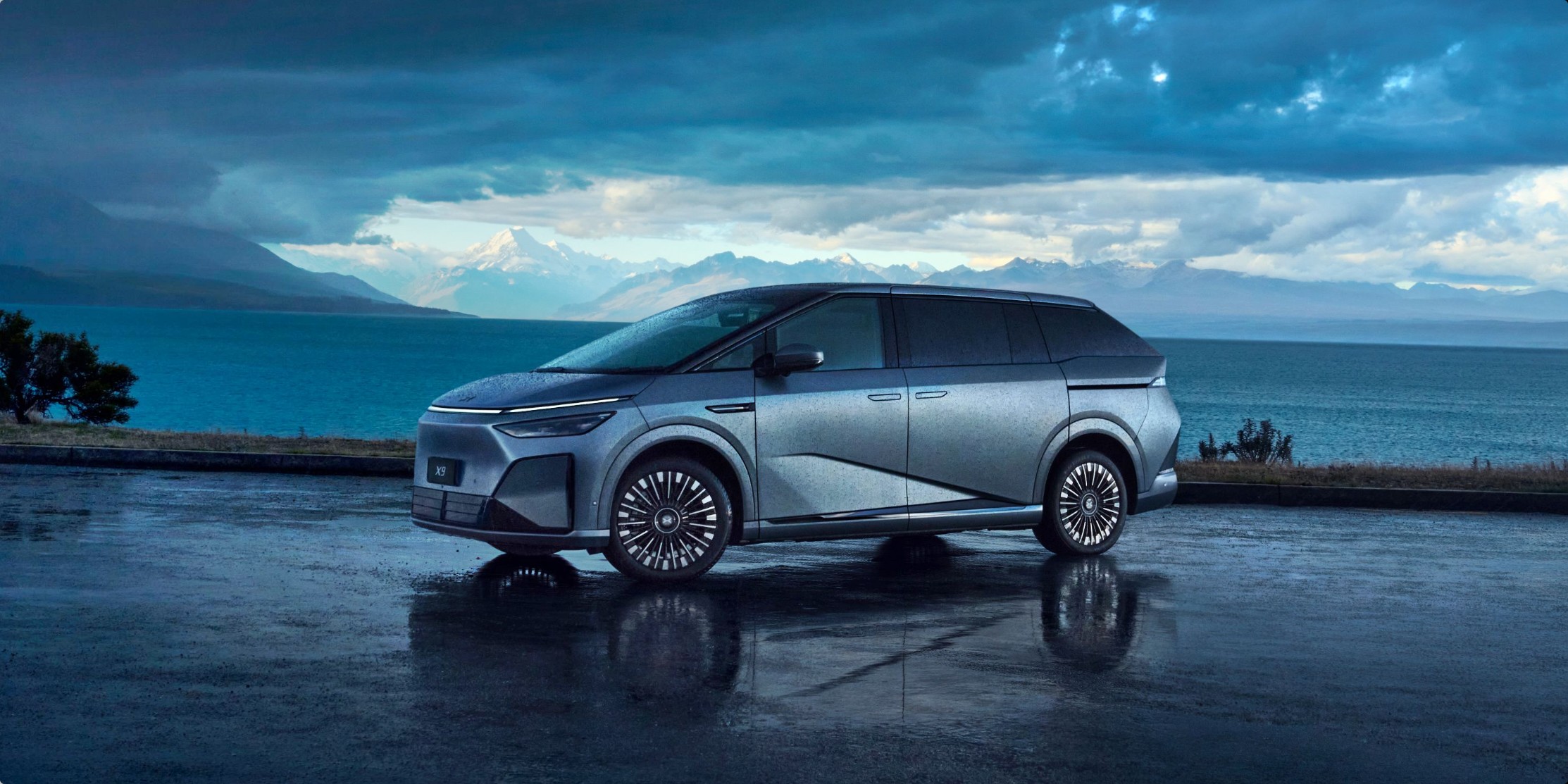 XPENG X9 front three-quarter view on a city street at dusk