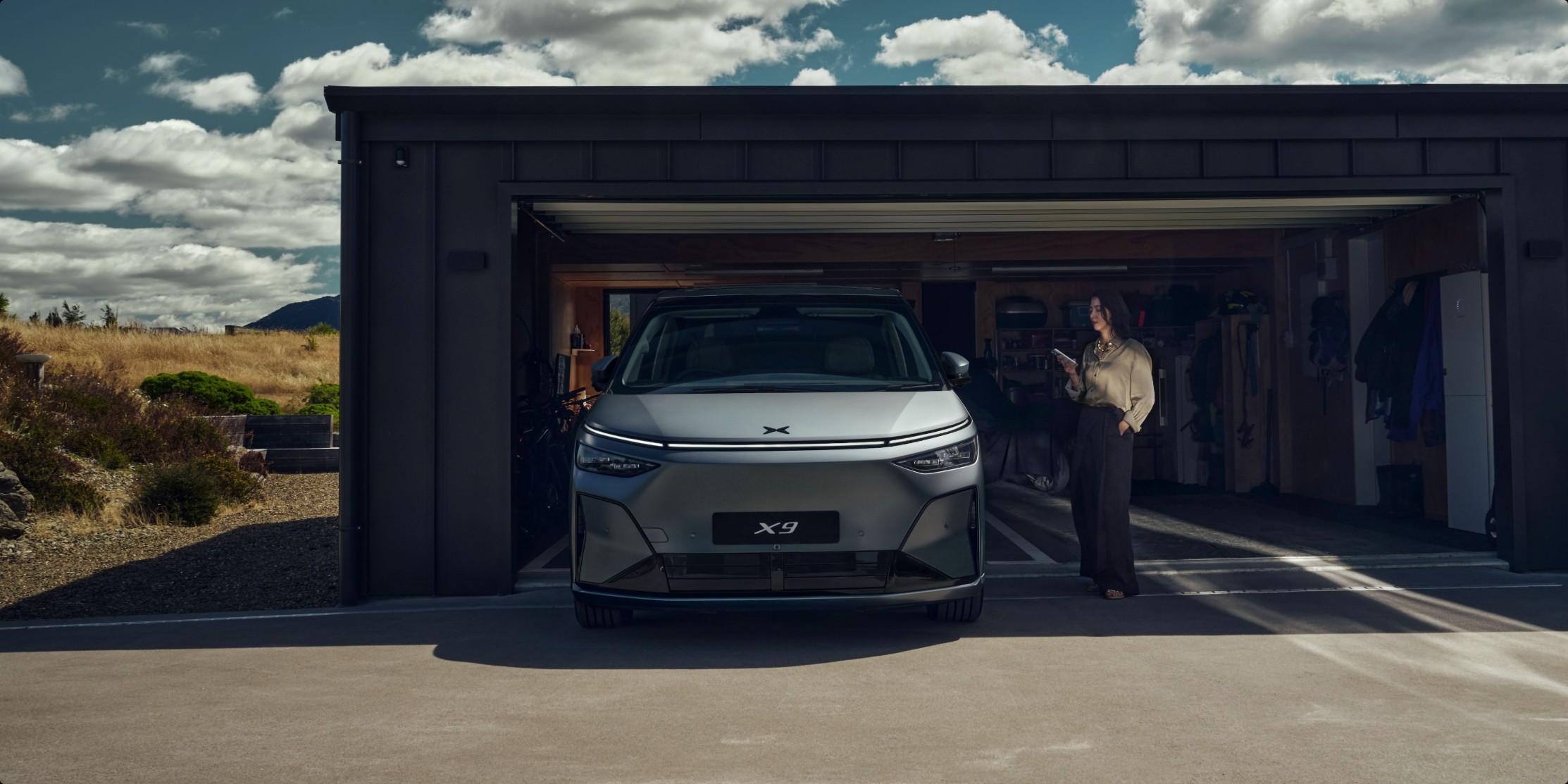 XPENG X9 parked nose-in at a modern garage